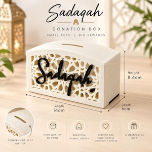 May include: A cream-colored Sadaqah donation box featuring an intricate geometric lattice pattern and the word Sadaqah in black script. It measures 14 cm in length, 8.4 cm in height, and 6 cm in depth, with a convenient slot on the top.