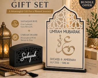 May include: An Umrah gift set featuring a black Sadaqah box with intricate cutouts and a wooden frame with an arched top. The frame displays the text Umrah Mubarak, Arabic calligraphy, and the names Shoaib and Ameenah with July 2026 and 1448 AH.