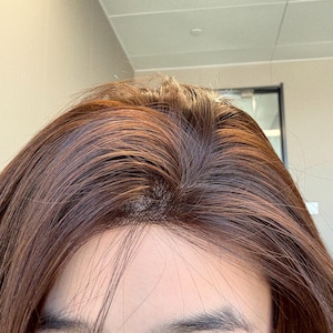 Puede incluir: Primer plano de cabello castaño con un tinte rojizo. El cabello está peinado con raya en la coronilla, revelando el cuero cabelludo. Las hebras son lisas y parecen saludables, con un brillo natural. La imagen está bien iluminada.