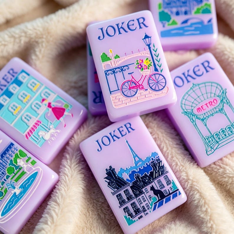 May include: A collection of rectangular light purple tiles, each labeled JOKER, featuring colorful illustrations of Parisian scenes including a bicycle with flowers, a metro entrance, a fountain, and a cityscape with the Eiffel Tower.