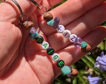 Llaveros personalizados con piedras preciosas en azul y morado con temática de la Feria de Scarborough.