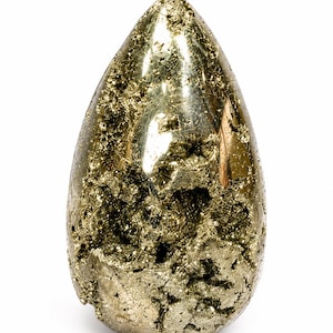 Puede incluir: Un espécimen de pirita en forma de lágrima con un brillo dorado metálico. La superficie presenta una combinación de áreas lisas y pulidas y una textura cristalina rugosa con grietas profundas y dentadas en toda la estructura.