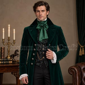 May include: A dark green velvet frock coat featuring a high collar, silver buttons, and a matching green satin cravat. The ensemble includes a black patterned waistcoat with a gold pocket watch chain and white lace cuffs extending from the sleeves.