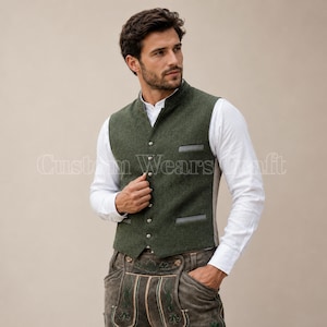 May include: A dark olive green wool vest featuring a V-neckline, a button-down front with silver-toned buttons, and two horizontal welt pockets. The vest is worn over a crisp white long-sleeved shirt, paired with dark brown leather trousers.