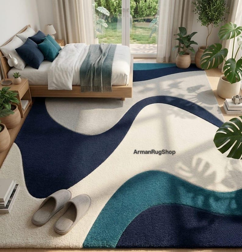 May include: A rectangular area rug featuring a wavy, abstract pattern in shades of navy blue, teal, and cream. The rug displays the text ArmanRugShop in the centre. The design consists of large, flowing organic shapes that span the entire surface.