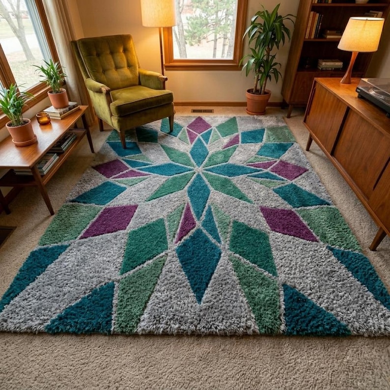May include: A large, geometric area rug with a starburst design. The rug features a pattern of teal, green, purple, and gray diamond shapes radiating from a central point. The rug is placed in a living room setting.