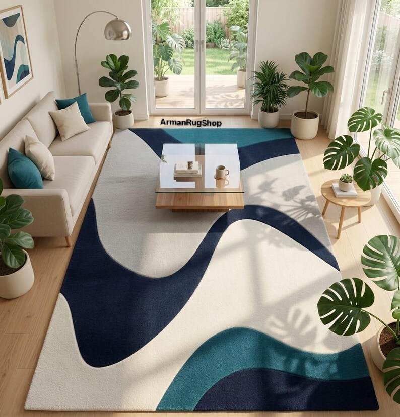 May include: A rectangular area rug featuring a large-scale abstract pattern with flowing, organic waves in shades of navy blue, teal, and cream. The rug is positioned in a living room setting and includes the text ArmanRugShop printed on the floor.