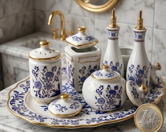 May include: A white ceramic bathroom set with blue floral designs and gold accents. The set includes bottles, jars, and a tray. The set is displayed on a marble surface. A one Euro coin is in the foreground.