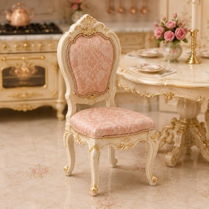 Peut inclure: Une chaise de maison de poupée miniature avec un cadre en bois crème aux accents dorés, un dossier haut arqué et une assise recouverte d'un tissu rose pâle orné d'un motif damassé floral blanc, reposant sur quatre pieds galbés de style cabriole.