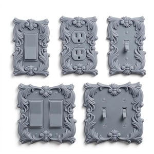 Puede incluir: Un conjunto de cinco placas de interruptores y cubiertas de enchufes eléctricas grises. Cada placa presenta un diseño floral decorativo y ornamentado alrededor del interruptor o enchufe. Las placas incluyen configuraciones de interruptores simples y dobles, y un enchufe doble.