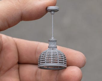 Może przedstawiać: Miniaturowa szara lampa wisząca z kloszem w kształcie kopuły o wzorze plecionej kratki. Lampa posiada cienki pionowy przewód łączący klosz z małym okrągłym mocowaniem sufitowym, całość wykończona w matowym szarym kolorze.
