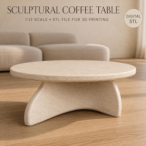 Peut inclure: Une table basse ronde beige avec une base sculpturale incurvée. Le texte indique : SCULPTURAL COFFEE TABLE, 1:12 SCALE, STL FILE FOR 3D PRINTING, et DIGITAL STL. Il s'agit d'un fichier numérique pour l'impression 3D d'un meuble miniature.