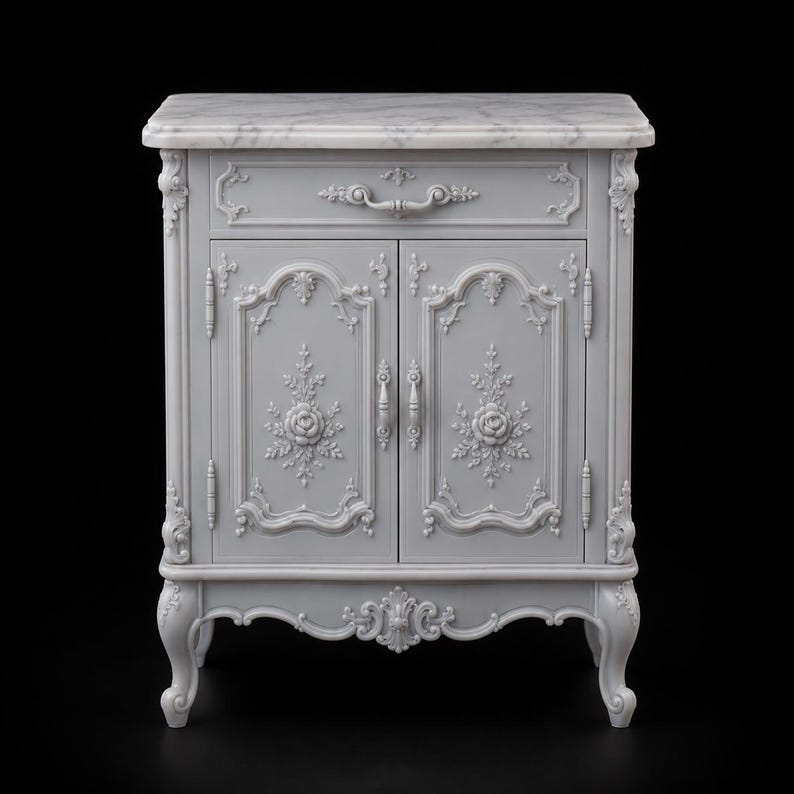 May include: A light gray cabinet featuring a white marble top, one drawer with a curved handle, and two doors. The front panels are decorated with intricate floral carvings and scrollwork, supported by four curved legs with ornate detailing.
