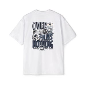 May include: White t-shirt with a graphic design featuring two cartoon robots and the text "OVERTHINKING SOLVES NOTHING BUT ACTION BRINGS CLARITY" in gray and blue. The design includes a thought bubble.