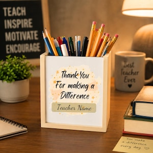 May include: A light-colored wooden pencil holder containing various colored pencils and pens. The front panel features a light orange watercolor-style background with gold stars and the black text: Thank You For making a Difference Teacher Name.