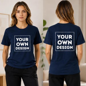 May include: A navy blue short-sleeved t-shirt featuring a white square outline with the text YOUR OWN DESIGN printed in the centre. The shirt is shown from both the front and back views, displaying the same graphic on the chest and the back.