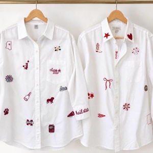 May include: Two white button-down shirts featuring various embroidered patches in red and other colors. The left shirt displays 'class of 2027' and 'hail state', while the right shirt features 'woo' and 'call' text, along with icons like stars, hearts, and boots.