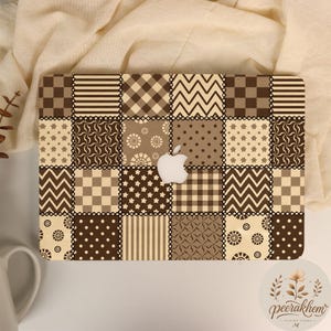 May include: A laptop hard shell case featuring a patchwork design of various brown and cream geometric patterns, including stripes, chevrons, polka dots, and floral motifs, with a central cutout revealing the white Apple logo on the laptop lid.