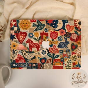Peut inclure: Une coque rigide pour ordinateur portable présentant un collage d'art populaire coloré avec des motifs rouges, bleus et jaunes incluant un soleil, une lune, des cœurs, un cheval, un lapin, des oiseaux et diverses fleurs autour du logo Apple blanc.