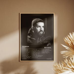 Puede incluir: Un póster enmarcado en blanco y negro con la portada del álbum Scorpion de Drake. La impresión muestra un retrato del artista, una lista de veinticinco canciones, un código de Spotify, la fecha de lanzamiento 29 de junio de 2018 y una duración total de 1 hora 30 min.