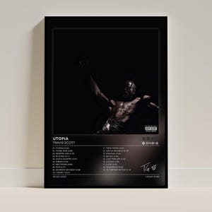 May include: A black framed poster featuring the Travis Scott Utopia album cover art. The design includes a dark, moody photograph of a person, a Parental Advisory label, the tracklist from 01 to 19, the date 28 July 2023, and a total runtime of 1 hour 13 min.