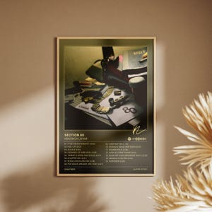 May include: A rectangular wall poster featuring the Section.80 album cover by Kendrick Lamar. The design includes a dark, moody photograph of a table with various items, the album title, tracklist, release date, and a gold signature graphic.