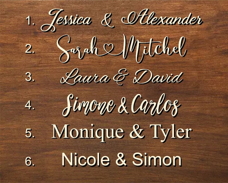 K&ouml;nnte beinhalten: Ein Holzschild mit einer Liste von Namen und Nummern. Die Namen sind in einer kursiven Schrift geschrieben und beinhalten Jessica & Alexander, Sarah Mitchel, Laura & David, Simone & Carlos, Monique & Tyler und Nicole & Simon.