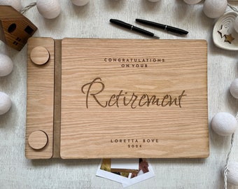 May include: Wooden guest book with a brown wood cover and a suede-like insert. The cover has the text "Congratulations on your Retirement" and "Loretta Bove 2024" engraved on it.