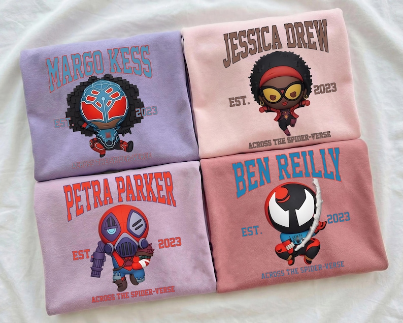 Puede incluir: Cuatro sudaderas en tonos morados y rosas, cada una con un dise&ntilde;o de personaje de dibujos animados y un nombre. Las sudaderas muestran los nombres "MARGO KESS", "JESSICA DREW", "PETRA PARKER" y "BEN REILLY", junto con el texto "EST. 2023" y "ACROSS THE SPIDER-VERSE".