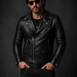 Könnte beinhalten: Schwarze Lederjacke mit einem strukturierten, reptilienartigen Muster. Die Jacke hat einen klassischen Biker-Stil mit einem Reverskragen, mehreren Reißverschlusstaschen und einem Frontreißverschluss. Die Person trägt eine Sonnenbrille und schwarze Jeans.