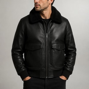 Può includere: Giacca bomber in pelle nera con colletto in ecopelliccia nera. La giacca ha due tasche frontali, chiusura con zip e polsini e orlo a coste. Un capo di abbigliamento esterno classico.