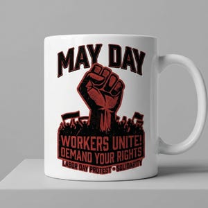 Op de afbeelding: Witte keramische mok met een rode en zwarte afbeelding. Het ontwerp toont de woorden "MAY DAY" boven een vuist, met de tekst "WORKERS UNITE! DEMAND YOUR RIGHTS LABOR DAY PROTEST SOLIDARITY" eronder.