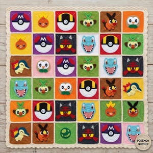 May include: A square crochet blanket featuring a grid of colorful squares, each displaying a different character or ball icon. The border is a scalloped cream-colored yarn. A small circular tag in the bottom right corner reads Pokémon Quilt.
