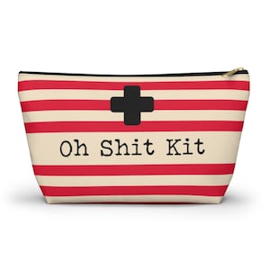Red and cream striped bag with the words "Oh Shit Kit" used for storing medicine and supplies.
