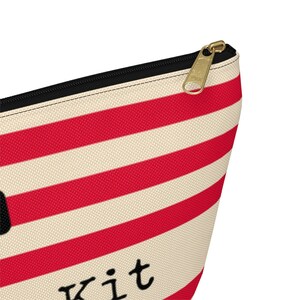 Red and cream striped bag with the words "Oh Shit Kit" used for storing medicine and supplies.