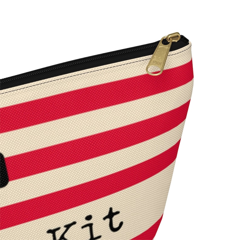 Red and cream striped bag with the words "Oh Shit Kit" used for storing medicine and supplies.