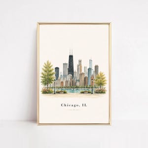 May include: A vertical framed art print featuring a watercolor illustration of the Chicago skyline. The city buildings are rendered in shades of gray, tan, and blue, with green trees in the foreground and the text Chicago, IL centered below.