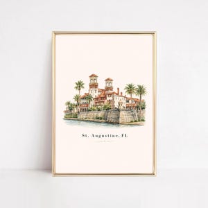 Könnte beinhalten: Ein Aquarell-Kunstdruck, der die historische Architektur von St. Augustine, Florida, mit terrakottafarbenen Dächern, Steinmauern und Palmen zeigt. Der Text St. Augustine, FL ist unten in der Mitte auf dem weißen Hintergrund schwarz gedruckt.