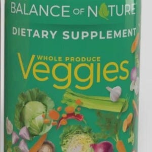 May include: A green bottle of dietary supplement capsules labeled "Balance of Nature." The bottle features the word "Veggies" with illustrations of vegetables. The bottle contains 90 capsules.