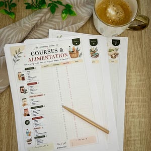 Könnte beinhalten: Mehrere bedruckte Einkaufszettel mit dem Titel "COURSES & ALIMENTATION" und Illustrationen. Eine Tasse Kaffee, ein Bleistift und dekorative Elemente liegen daneben.