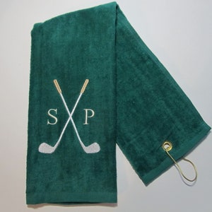 May include: Green golf towel with a white embroidered design of two crossed golf clubs and the letters "S" and "P".