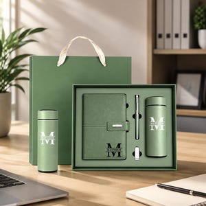 May include: A sage green gift set featuring a notebook, a pen, a small USB drive, and two insulated tumblers. Each item is personalized with the name Matthew and a large letter M. The set includes a matching green gift bag with a white ribbon handle.