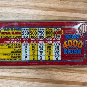 May include: A rectangular video poker pay table sign framed in wood with a red background. The sign displays a grid of winning hands and coin payouts from 1 to 5 coins, featuring the text WIN 4000 COINS WITH 5 COINS PLAYED and a circular logo.