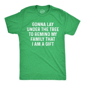 May include: Green t-shirt with the text "Gonna lay under the tree to remind my family that I am a gift" in white.