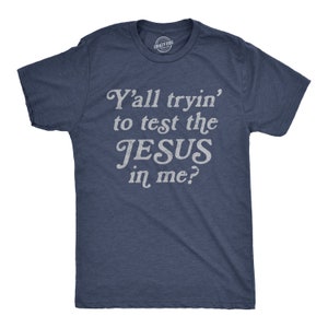 May include: A navy blue t-shirt with a white distressed graphic that reads "Y'all tryin' to test the JESUS in me?"