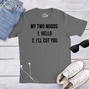 May include: A heather gray t-shirt with the text "MY TWO MOODS: 1. HELLO 2. I'LL CUT YOU" printed in black.