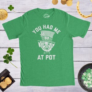 May include: Green t-shirt with a white graphic of a leprechaun with a pot of gold and the text "You had me at pot".