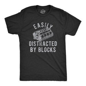 May include: A black t-shirt with a white graphic of an engine block and the text "Easily Distracted By Blocks".
