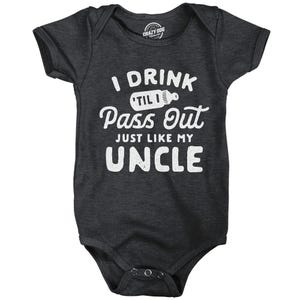 May include: A dark grey baby onesie with white text that reads "I drink til I pass out just like my uncle". The onesie has a white baby bottle graphic with the word "til" inside.