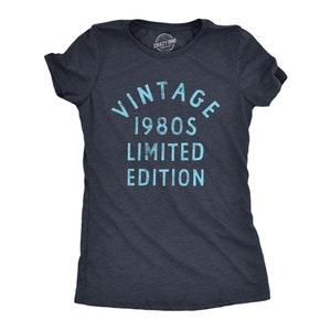 May include: Dark navy blue t-shirt with the text "VINTAGE 1980S LIMITED EDITION" in light blue. The shirt has short sleeves and a crew neck. The Crazy Dog brand logo is visible at the top.